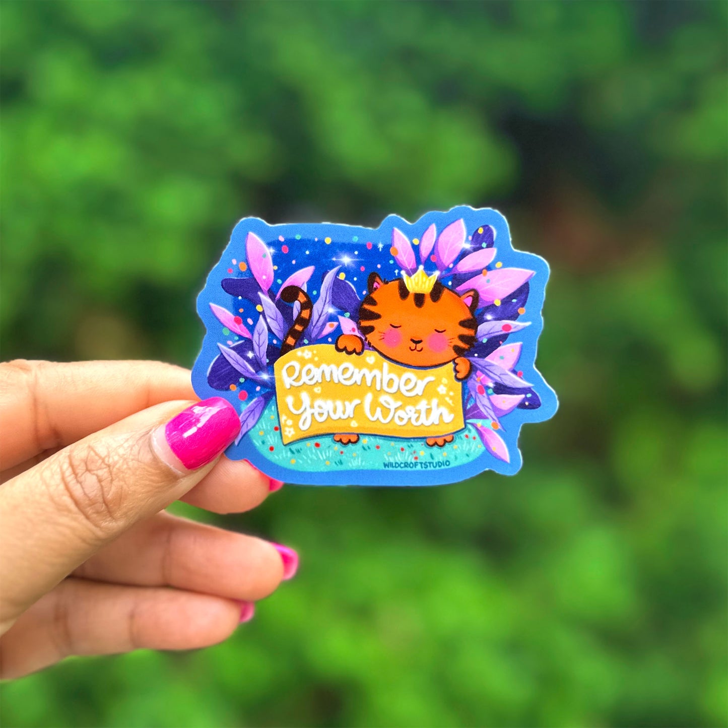a hand holding a sticker with a picture of a cat on it