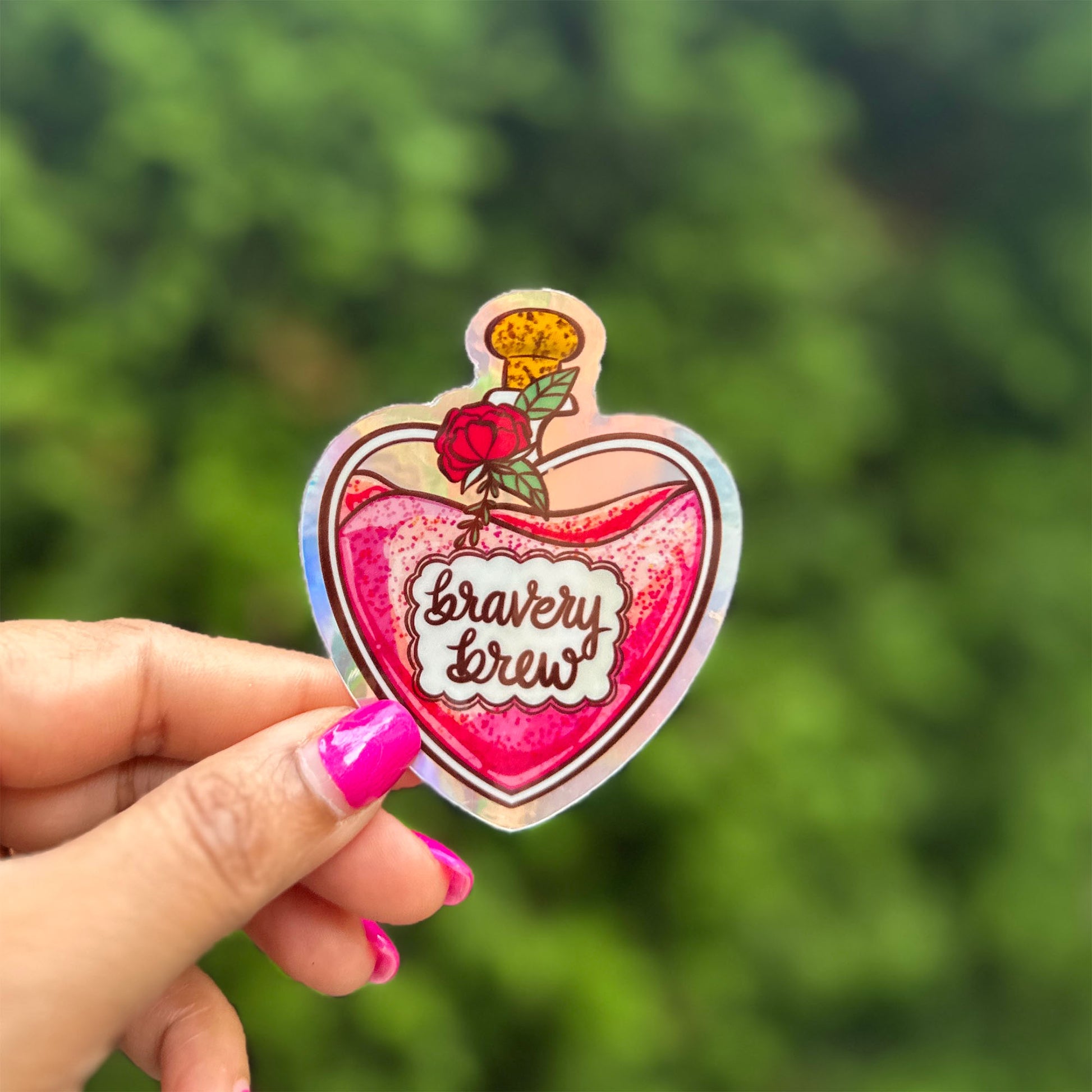 a hand holding a heart shaped sticker with a rose on it