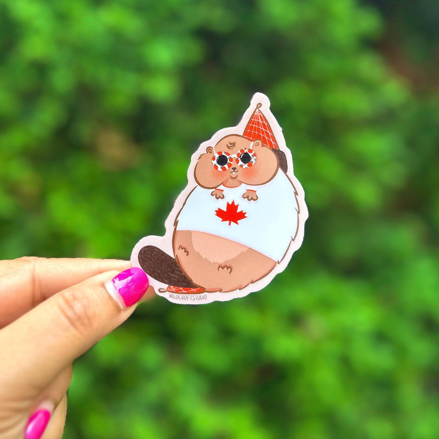 a person holding up a sticker with a picture of a pig on it