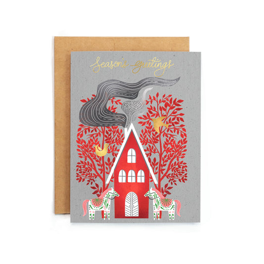 a greeting card with a red house and trees