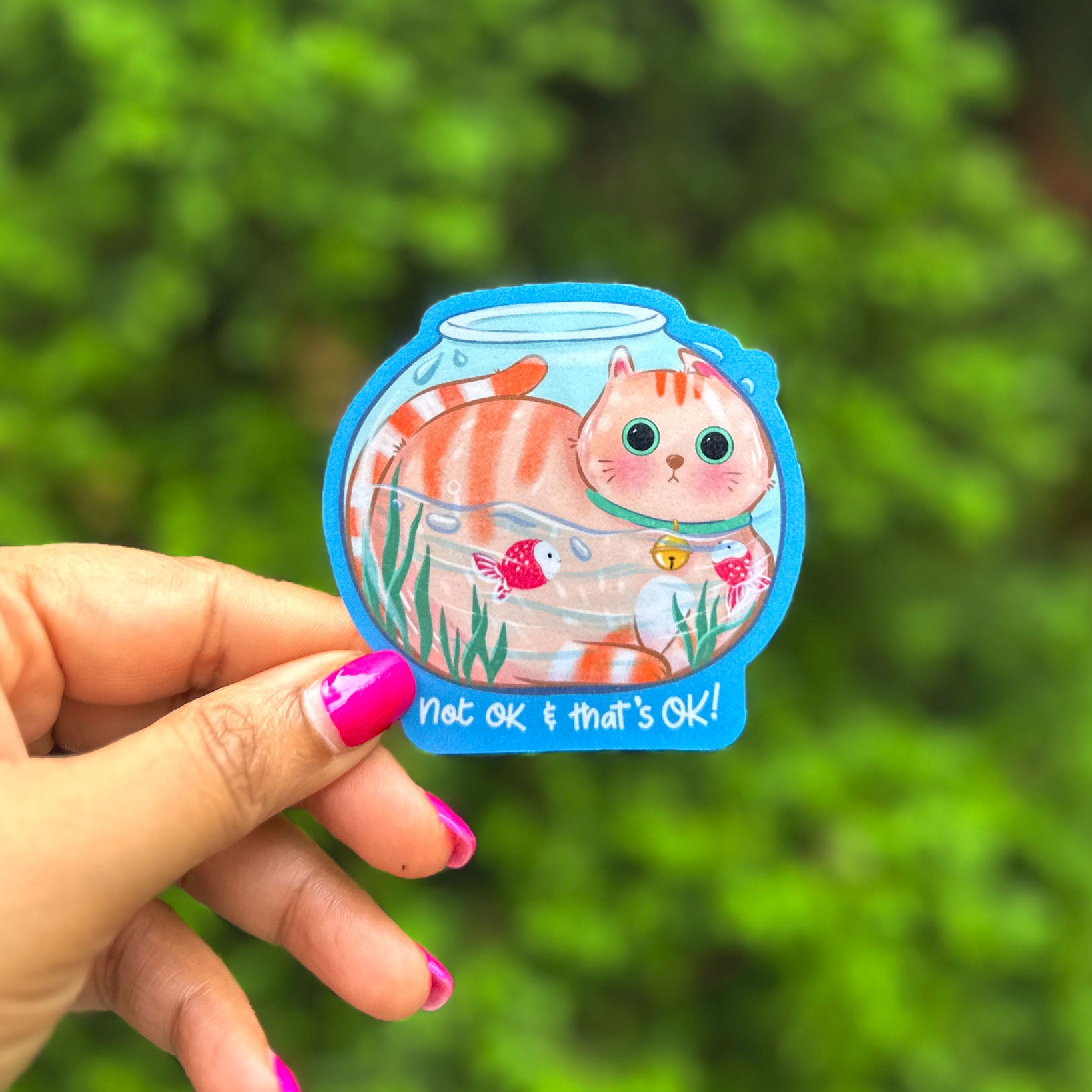 a hand holding a sticker with a cat on it