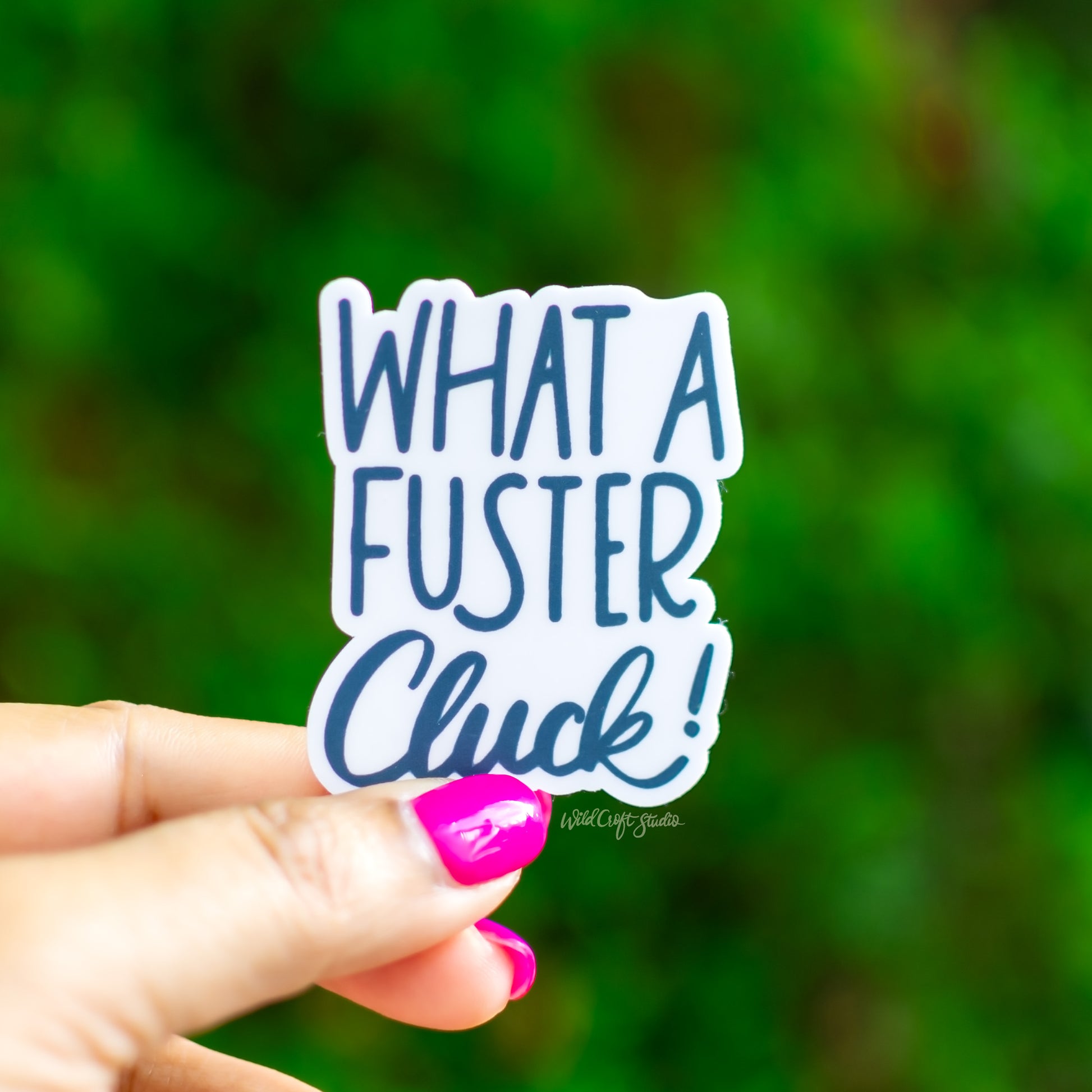 a person holding a sticker that says, what a fuster chuck