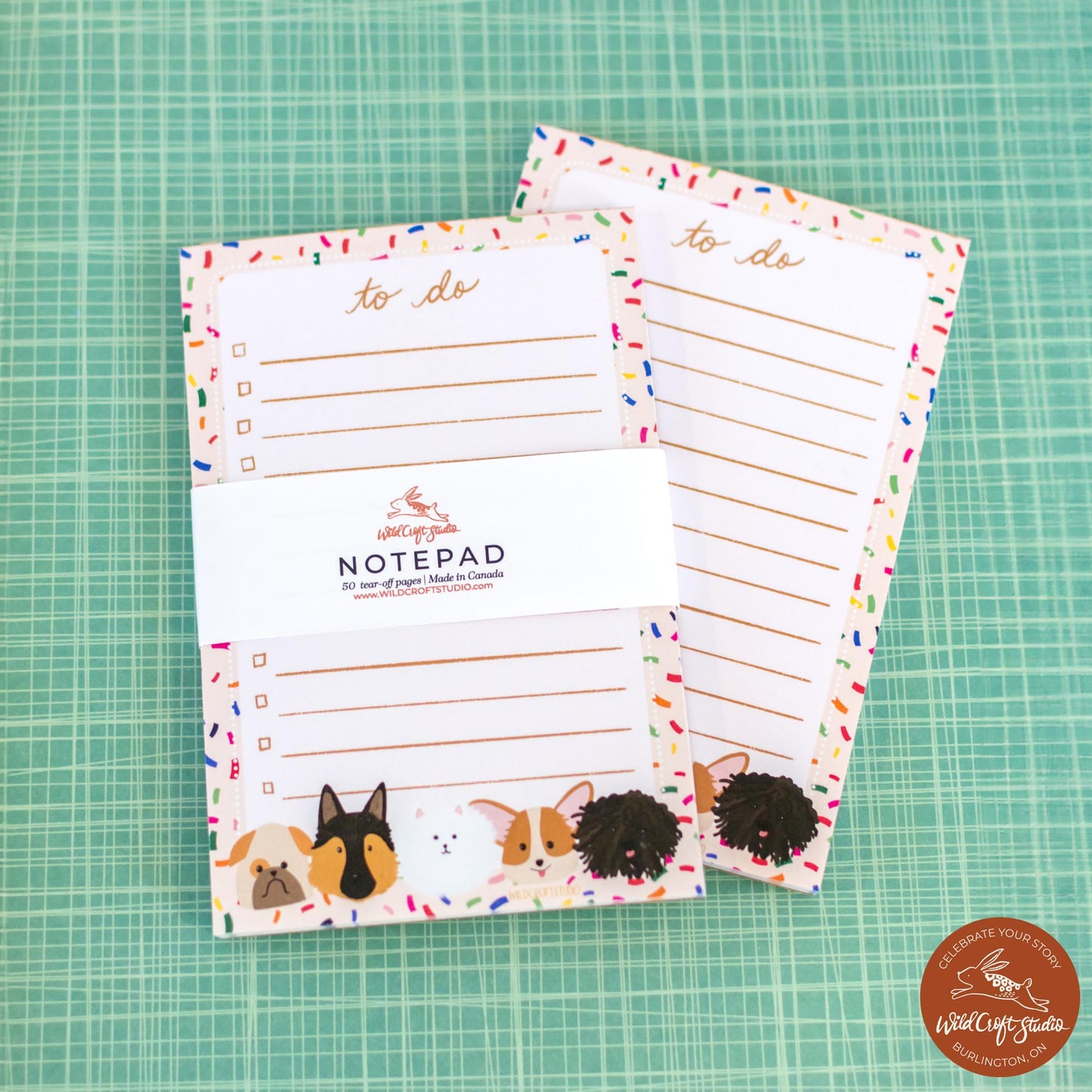 two notepads with dogs on them sitting on a table
