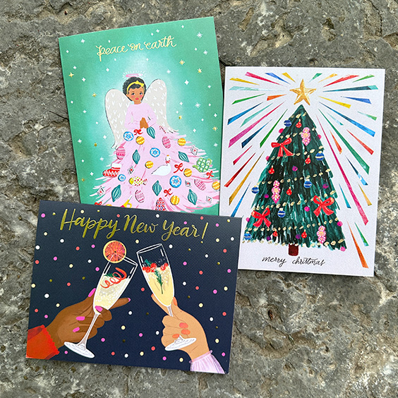 three christmas cards on a stone surface