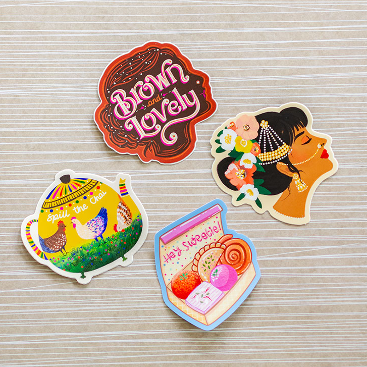 a group of four stickers sitting on top of a wooden table