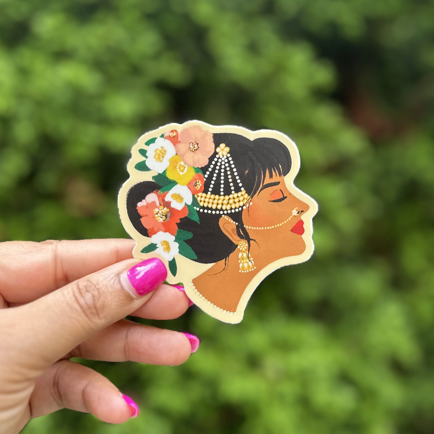 a hand holding a sticker of a woman's face
