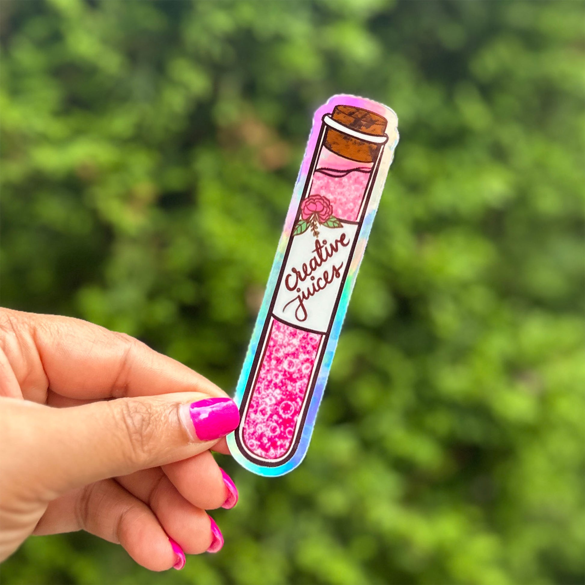 a hand holding a pink sticker with a picture of a jar on it