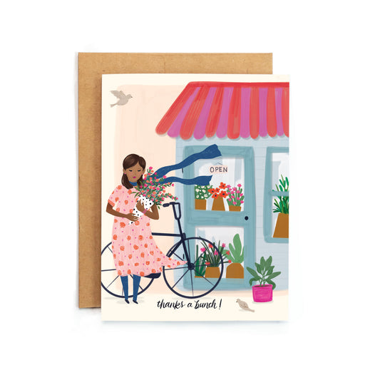 a card with a woman on a bicycle holding flowers
