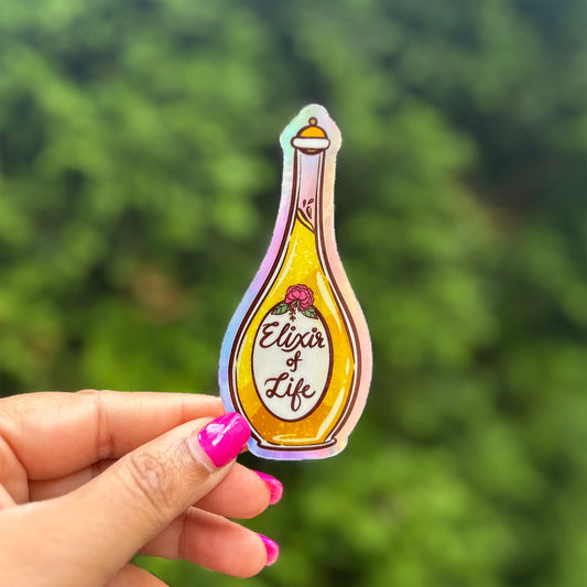 a hand holding a sticker of a bottle of eliot of life
