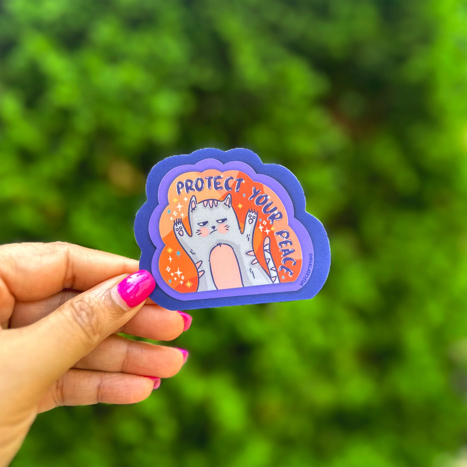 a hand holding a sticker with a picture of a cat