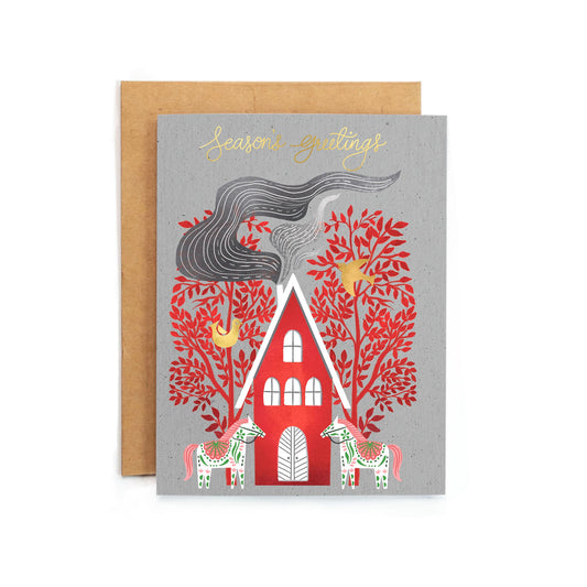 a greeting card with a red house and trees