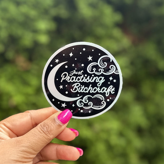 a person holding up a sticker with a picture of the moon and stars on