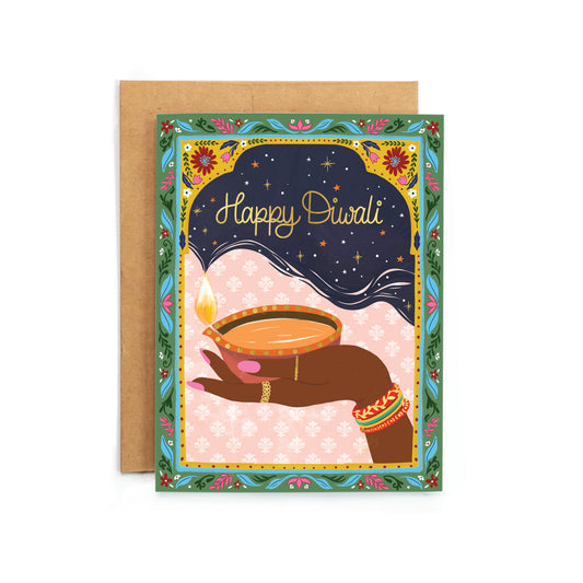 a happy diwali card with a hand holding a lit candle