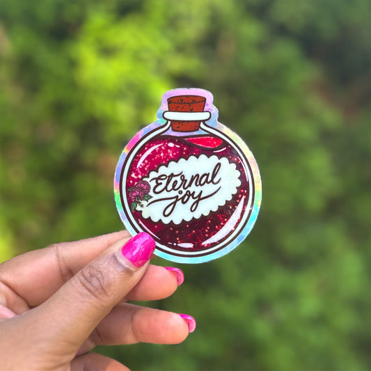 a hand holding up a sticker with the words crystal joy on it