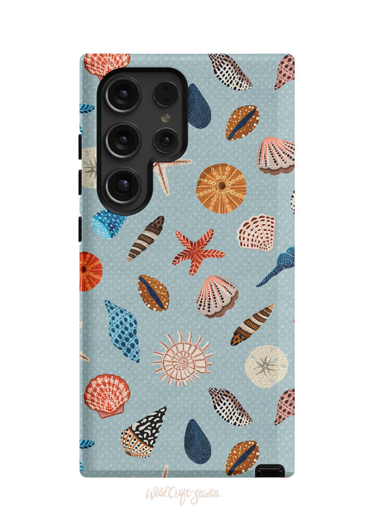 a phone case with shells on a blue background