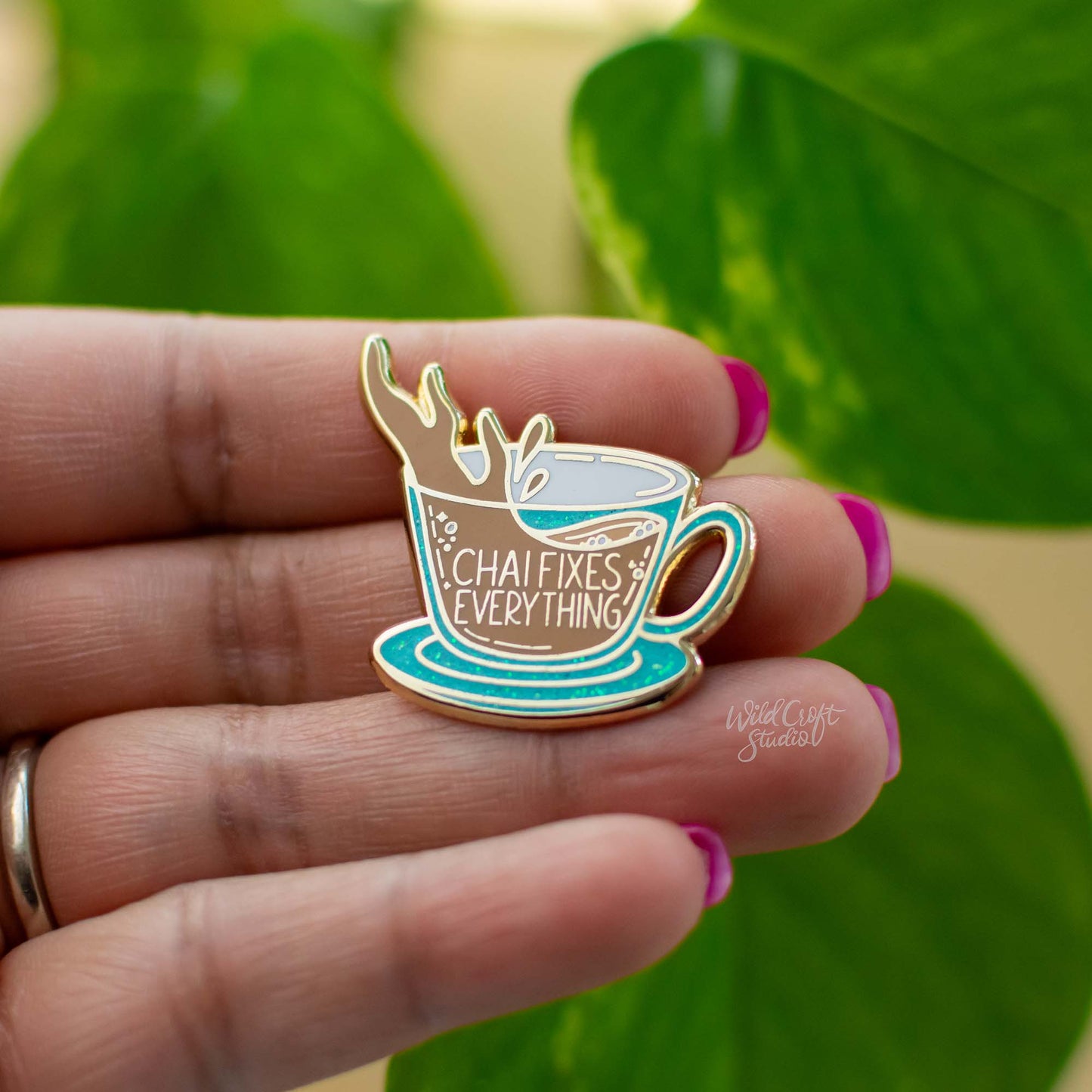 a person holding a pin with a cup of coffee on it
